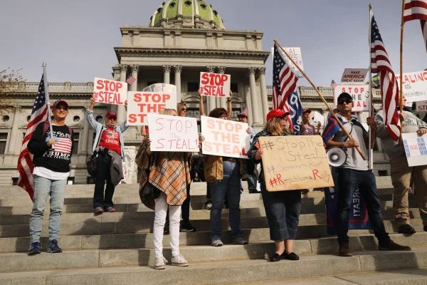 protesters in pennsylvania hold up signs to protest alleged voter fraud in the us 2020 election. georgia is going to have a hand recount