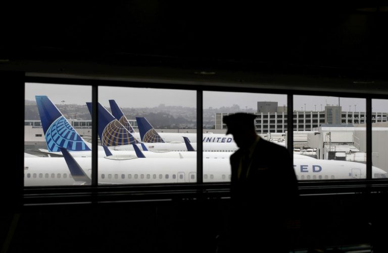 A pilot walks by United Airlines gated planes at San Francisco International Airport. United Airlines seeks to shift this male dominated field, announcing that 50 percent of new pilots will be women or people of color.