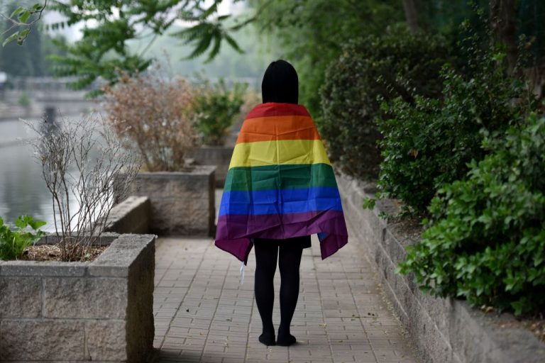 In this photo taken on May 10, 2019, an LGBT student posed with a rainbow flag in Beijing. In China that year, censors shut down some of its social media forums, online news media curbed coverage of gay issues, and online shops removed sales of rainbow-themed products.