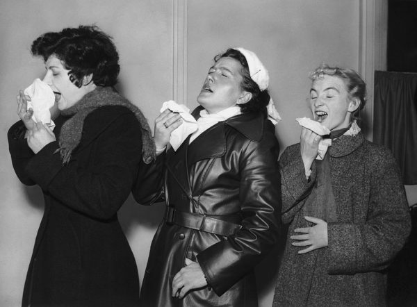 Three volunteers are infected with the common cold virus for research purposes at the Harvard Hospital in Wiltshire, 28th December 1955. From left to right, they are student Brenda Jeanes, German tourist Anne Weddig and civil servant Pat Brown. Canadian Vadim Ilyinsky was arrested and charged by Toronto Police for Mischief after sneezing on an Air Canada flight from Mexico in August of 2020.
