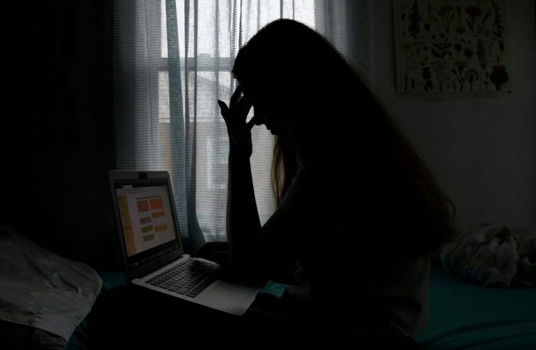 In this photo illustration, a teenager poses for a picture with a laptop in Arlington, Virginia, June 11, 2021. A UK study found suicide killed five times more people under 18 than COVID-19, and abuse more than ten times more.