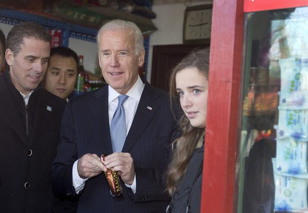 Then-U.S. Vice President Joe Biden (C) buys an ice-cream at a shop as he tours a Hutong alley with his granddaughter Finnegan Biden (R) and son Hunter Biden (L) in Beijing on December 5, 2013. Hunter hitched a ride on Air Force Two with his dad to make a business deal with no less than the Bank of China.