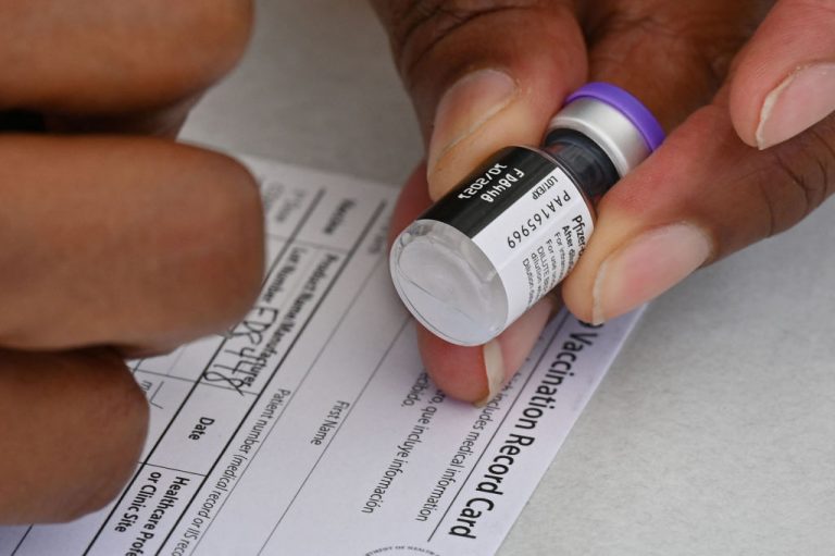 A healthcare worker fills out a COVID-19 vaccination card at a community healthcare event in a predominantly Latino neighborhood in Los Angeles, California, August 11, 2021.