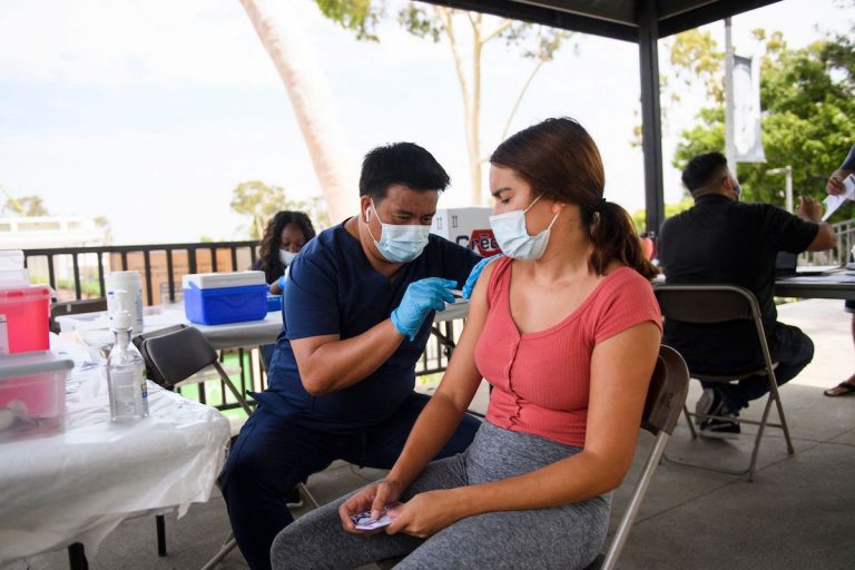 A CSULB student receives a first dose of the Pfizer Covid-19 vaccine during a City of Long Beach Public Health Covid-19 mobile vaccination clinic at the California State University Long Beach (CSULB) campus on August 11, 2021 in Long Beach, California. Students, staff, and faculty at the California State University (CSU) and University of California (UC) system schools will be required to be fully vaccinated in order to attend in-person classes.