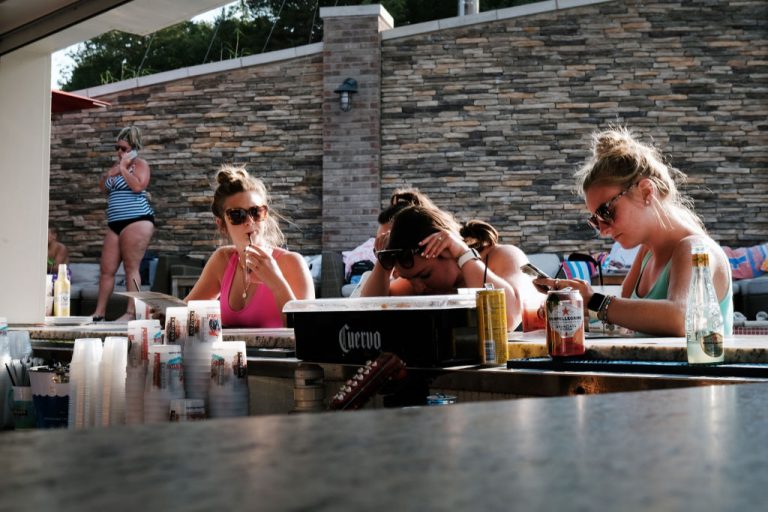 Young people enjoy an afternoon at a swimming pool and bar in Osage Beach, Missouri. Recent data published by Axios found young people are self-enforcing vaccine passports on their friends and family. The decline of family values and brotherly love, however, can be directly attributed to Marxist indoctrination and is driven by big media.