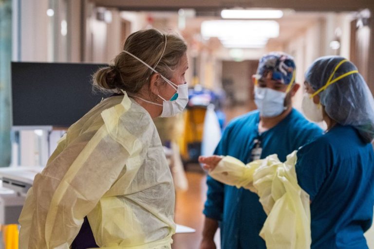 Registered nurse Katie Katie (L) and other nurses, put on personal protective equipment before tending to a Covid-19 patient inside the intensive care unit at Adventist Health in Sonora, California on August 27, 2021.