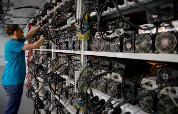An employee inspects hardware at the CryptoUniverse data centre during a presentation of the largest crypto currency centre in Russia in Kirishi on August 20, 2018. Bitcoin’s data centers are many times less efficient than Visa’s while processing a meager fraction of transactions. Instead, cryptocurrency’s semiconductor and electrical consumption go towards solving a math problem in an effort to win coins issued by the software.