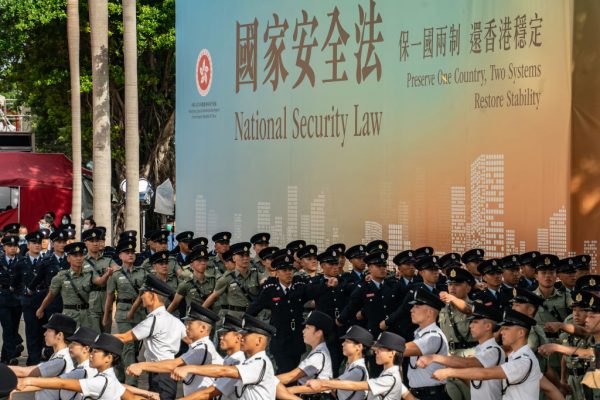 Hong Kong Police put on a display of force at Golden Bauhinia Square in front of a propaganda banner promoting the NSL on July 1, 2020 in Hong Kong. The National Security Law has effectively eliminated democracy and installed totalitarianism years ahead of the expiration of the CCP’s “One Country, Two Systems” contract with England. 