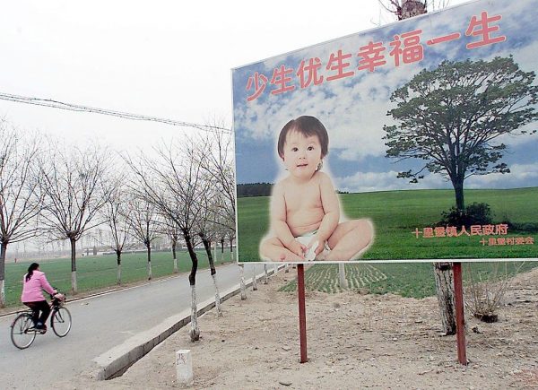 A woman cycles past a billboard encouraging couples to have only one child, along a road leading to a village in the suburb of Beijing in March of 2001. The CCP’s much-decried One Child Policy has had serious economic and social consequences for the country. Even a relaxation to a two and three-child policy has not rectified China’s population crisis. 