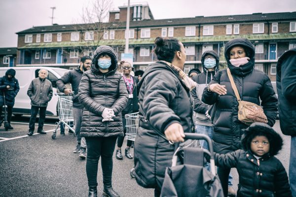 Local residents line up on an urban London street during the COVID-19 pandemic on March 19, 2020. Concerns about the UK's third wave affecting the vaccinated and children are reflected in the SPI-M-O report. 