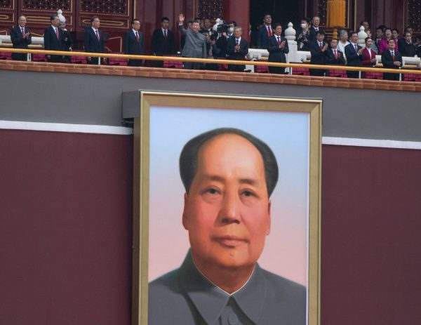 Chinese President and Chairman of the Communist Party Xi Jinping, top center, waves to the crowd after his speech above the portrait of the late Chairman Mao Zedong at a ceremony marking the 100th anniversary of the Communist Party.