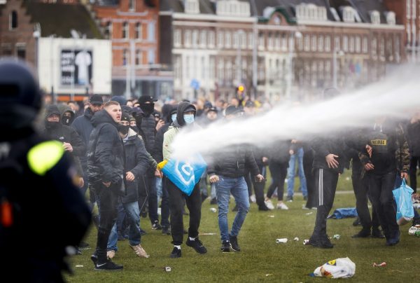 Demonstrators are sprayed by police water cannon at Amsterdam’s Museumplein during a protest against the lockdown imposed to curb the spread of the Covid-19 pandemic and the outgoing government’s policy, on January 21, 2021. 