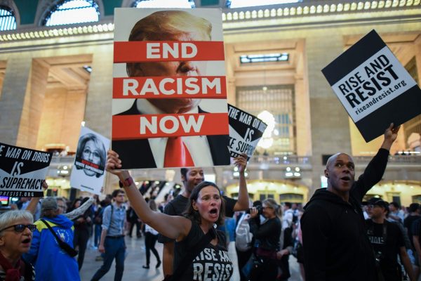 Protesters shout slogans and wave placards against U.S. President Donald Trump during the Rise and Resist Against White Supremacy demonstration inside the Grand Central Station in New York on September 18, 2017.