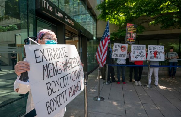 Protesters hold up a sign outside British Columbia Supreme Court where Meng Wanzhou attended a hearing on May 27, 2020, in Vancouver, Canada. Meng has been under house arrest in Vancouver for more than two years. 