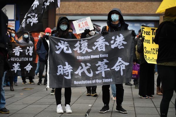 Protesters gather with banners at an event organized by Justitia Hong Kong to mourn the loss of Hong Kong’s political freedoms, in Leicester Square, central London on December 12, 2020. Britain expressed alarm on Friday after Hong Kong media tycoon and Beijing critic Jimmy Lai, who has UK citizenship, became the most high-profile figure yet charged under sweeping national security law. 