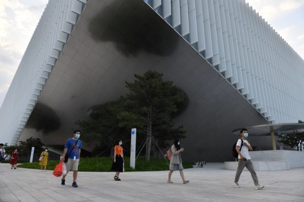 Staff walk out from the headquarters building of Tencent, the parent company of Chinese social surveillance system WeChat, in Beijing on August 7, 2020. The reason China blocks Signal is to hem Chinese netizens into using WeChat, where CCP surveillance and censorship are a part of everyday life.