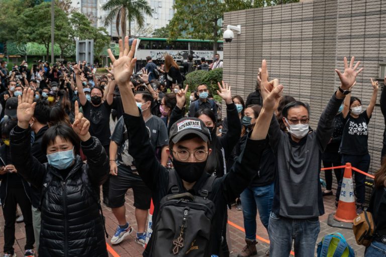 Pro-democracy activists make gestures and shout slogans outside the West Kowloon court on March 1, 2021 in Hong Kong. The protest took place during the court appearances by dozens of dissidents charged with subversion in the largest use of Beijing's sweeping new national security law to date.