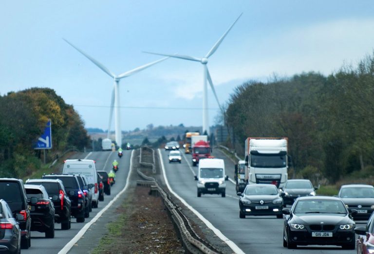 Windmills loom over a Scottish highway on Monday where a motorcade carrying US President Joe Biden drives from the airport towards the Scottish city of Edinburgh where he will stay during the COP26 meeting. Biden will expound on his plans to curb global carbon production.