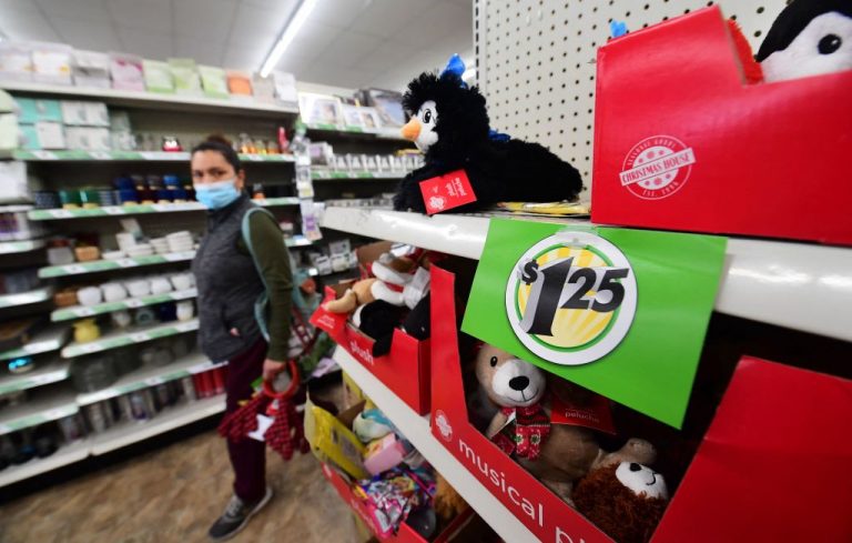A shopper walks by a sign displaying $1.25 price, posted on the shelves of a Dollar Tree store in Alhambra, California, December 10, 2021. Results of a new Associated Press poll found Americans reporting they’re paying more for household expenses.