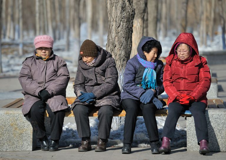 Elderly people sit on a chair at An Yang park on February 27, 2018 in Harbin, China.