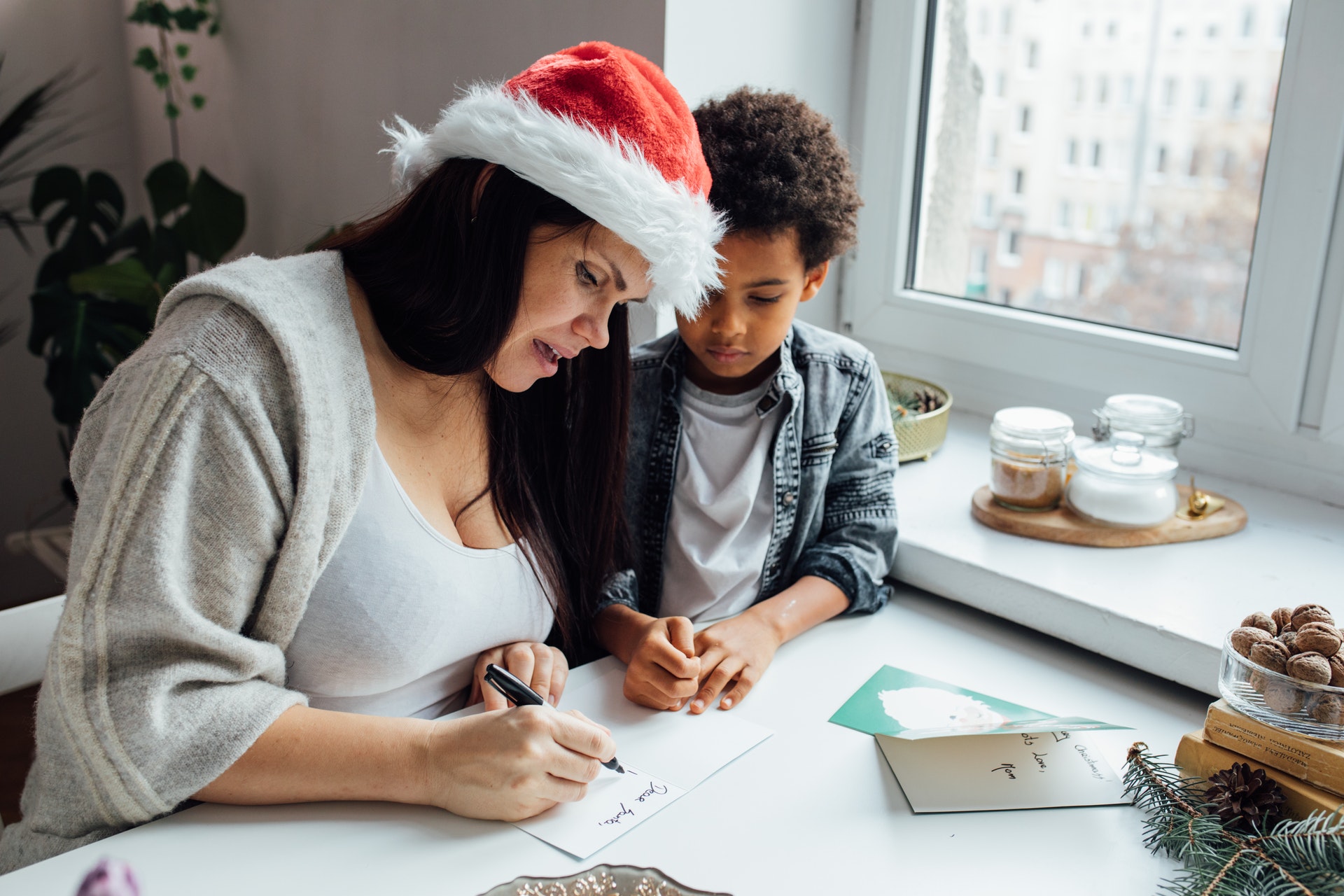 Mother-and-son-writing-holiday-cards-Pexels