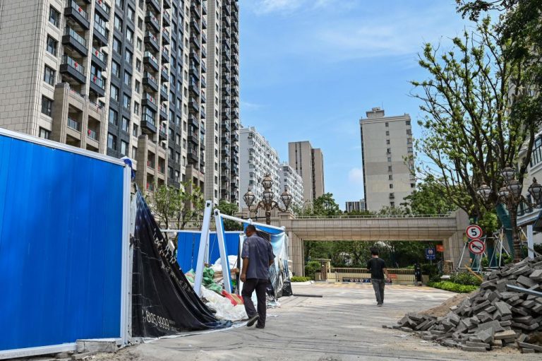 A man walks past a residential building developed by Evergrande.