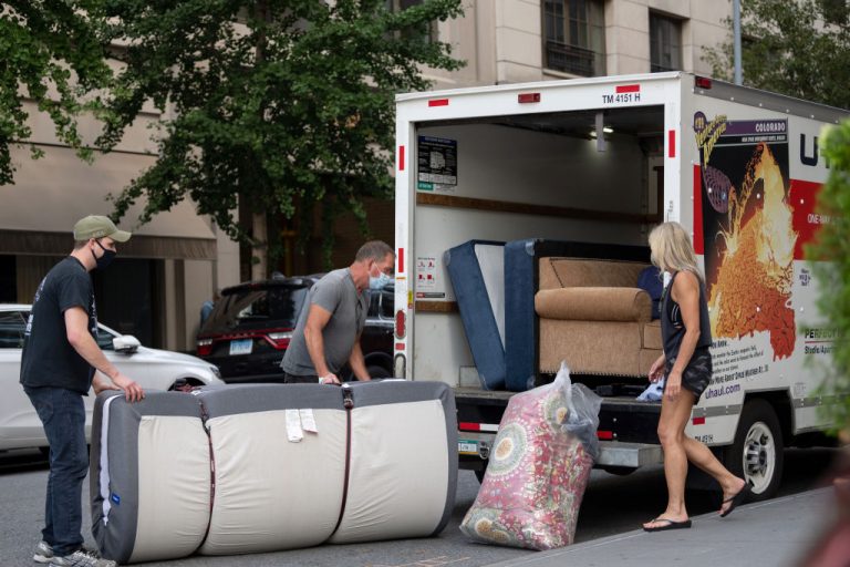 New Yorkers load furniture into a U-haul moving truck in New York City.