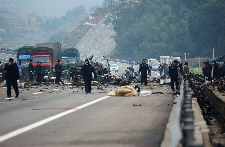 Police officers investigate the site of a bus explosion in China.