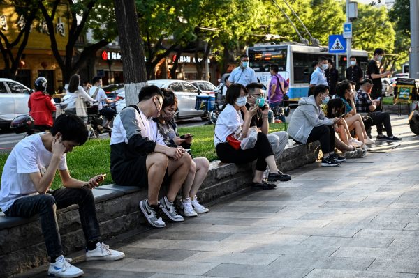 china-people-sitting-outside-on-street-face-masks_GettyImages-1241149187.jpg