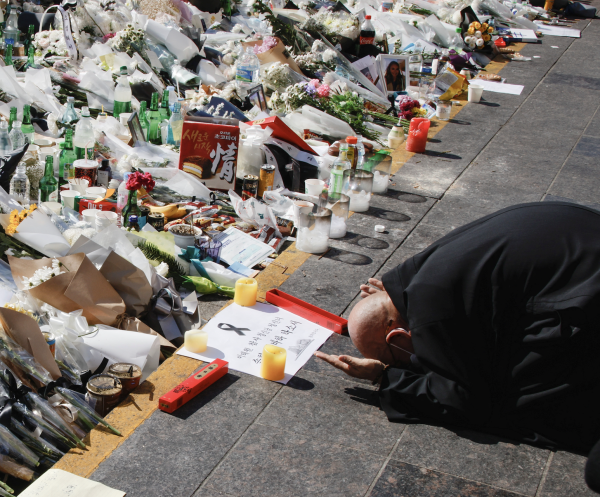 A man pays respect near floral tributes following a crowd crush that happened during Halloween festivities in Seoul, South Korea, November 2, 2022. (Image: Screenshot / REUTERS)