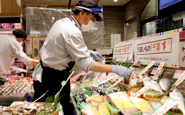 A staff wearing a face shield sells fish at Japan's supermarket group Aeon's shopping mall as the mall reopens amid the coronavirus disease (COVID-19) outbreak in Chiba, Japan May 28, 2020. (Image: Screenshot / REUTERS)