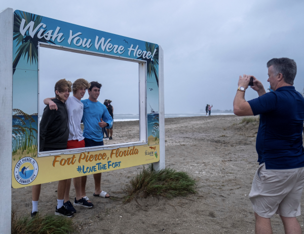 A man takes a photo of a group of three boys in the Inlet State Park before the expected arrival of Tropical Storm Nicole in Fort Pierce, Florida, U.S. November 9, 2022. (Image: Screenshot / REUTERS)