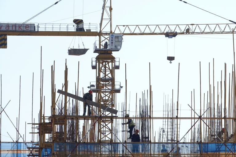 A Vanke sign is seen above workers working at the construction site of a residential building in Dalian, Liaoning province, China September 16, 2019. (Image: Screenshot / REUTERS)