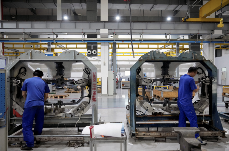 Employees work on the production line of high speed train components during a government-organised media tour to a factory of German engineering group Voith, following the coronavirus disease (COVID-19) outbreak, in Shanghai, China July 21, 2022. (Image: Screenshot / REUTERS)