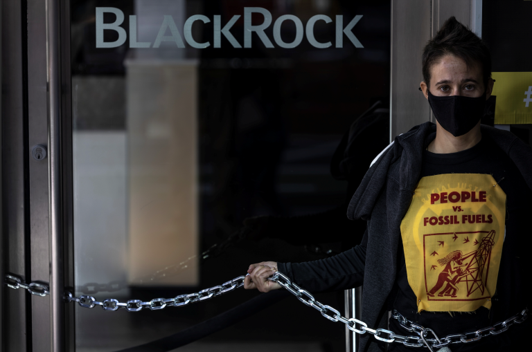 A climate change activist stands outside of BlackRock headquarters, ahead of the 2021 United Nations Climate Change Conference (COP26), in San Francisco, California, U.S., October 29, 2021. (Image: Screenshot / REUTERS)