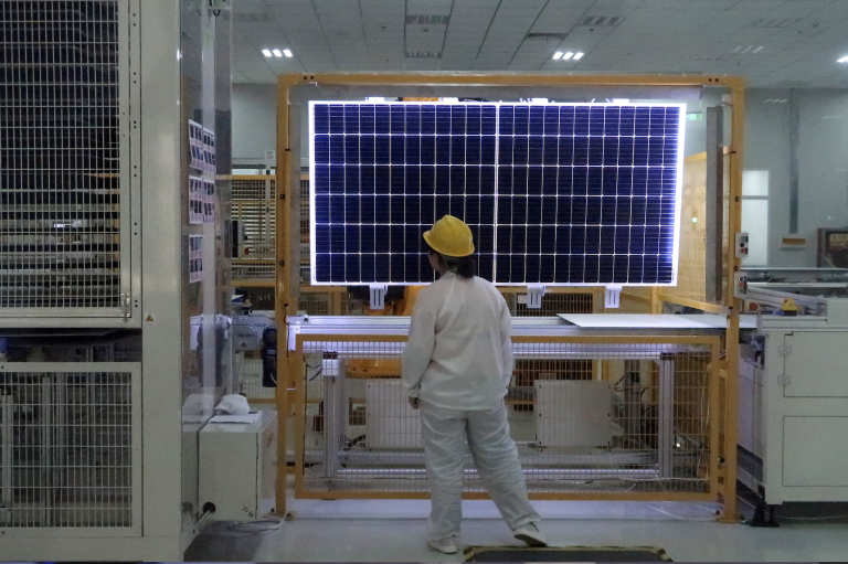 A worker conducts quality-check of a solar module product at a factory of a monocrystalline silicon solar equipment manufacturer LONGi Green Technology Co, in Xian, Shaanxi province, China December 10, 2019. (Image: Screenshot / REUTERS)