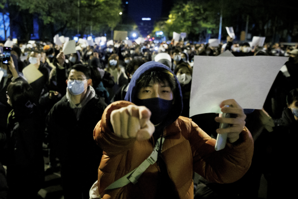 Las personas sostienen hojas de papel blancas en protesta por las restricciones de la enfermedad por coronavirus (COVID-19) después de una vigilia por las víctimas de un incendio en Urumqi, mientras continúan los brotes de COVID-19, en Beijing, China, el 27 de noviembre de 2022. (Imagen: Captura de pantalla / Reuters)