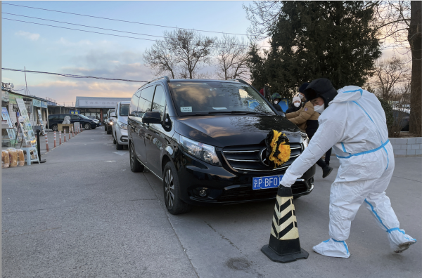 A worker in a protective suit removes a cone in front of a hearse outside a funeral home amid the coronavirus disease (COVID-19) outbreak in Beijing, China, December 17, 2022. (Image: Screenshot / Reuters)