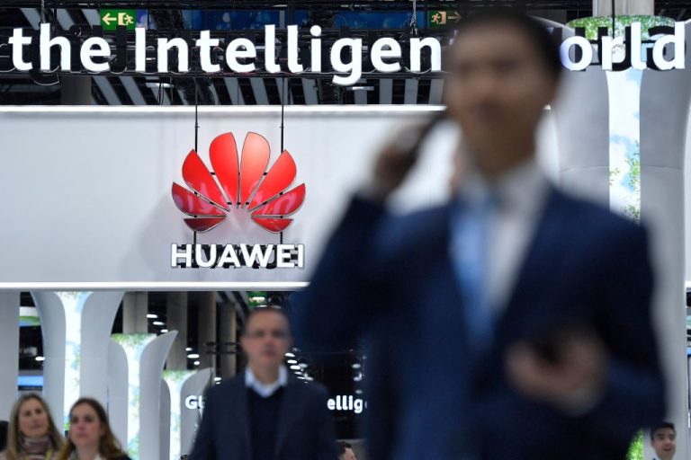 Visitors walk next to Chinese manufacturer Huawei stand at the Mobile World Congress (MWC) on February 28, 2023.