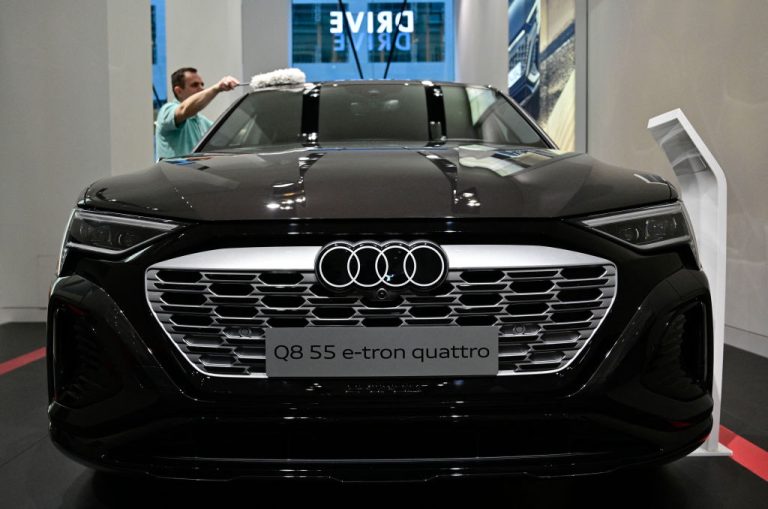 a-worker-polishes-an-audi-q-8-55-e-tron-quattro-car-on-the-sidelines-of-the-annual-press-conference-of-german-car-giant-volkswagen-vw-on-march-14-2023-in-berlin