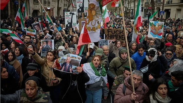 Protesters holding Iranian flags and banners during a demonstration in Paris.
