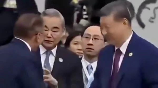 Chinese officials appear tense while attending an international delegation during a public event.
