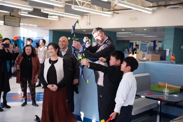 U.S. Rep. Patrick Ryan plays a toy archery game with children at a Chinese New Year celebration hosted by the Middletown Chinese community in New York.