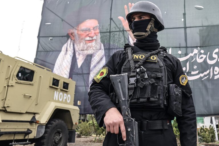 A member of the Iranian security forces stands guard next to a banner honouring Iran’s slain supreme leader Ayatollah Ali Khamenei in Tehran on March 31, 2026.